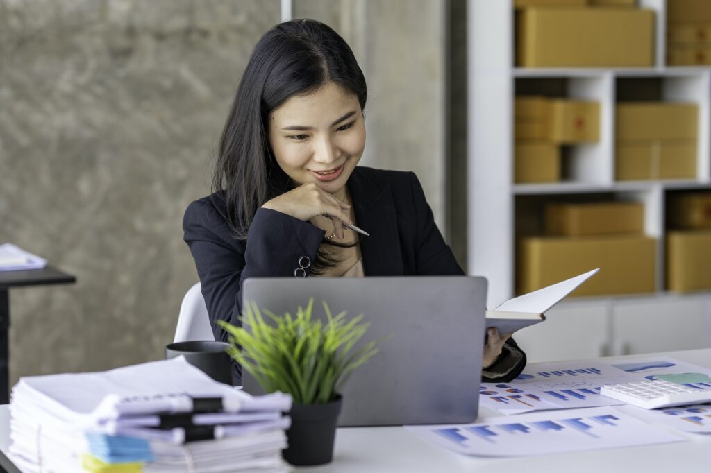 Young Asian businesswoman working online with laptop computer while sitting in office. Self-employed